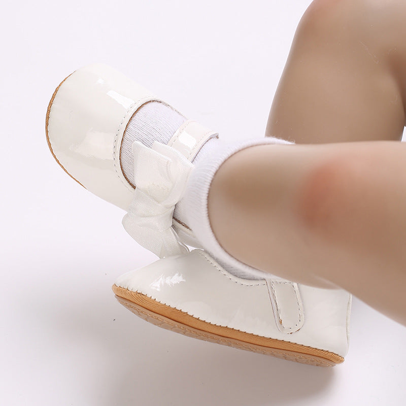 Patent leather shoe with a bow.