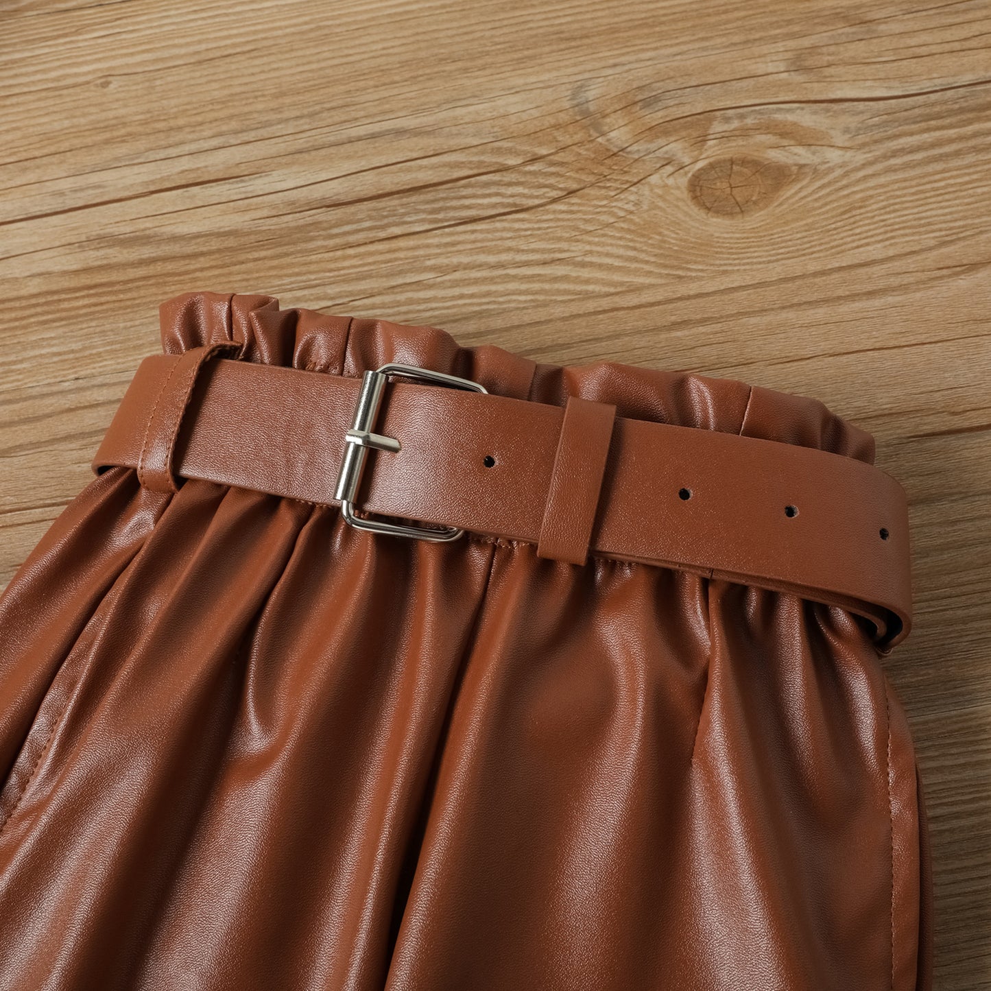 Conjunto infantil con pantalón marrón con cinturón.