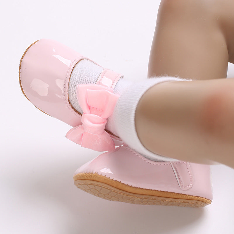 Patent leather shoe with a bow.