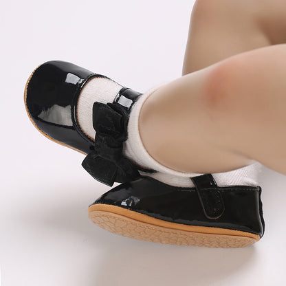 Patent leather shoe with a bow.