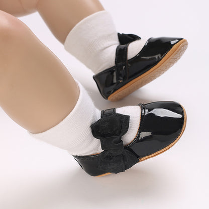 Patent leather shoe with a bow.