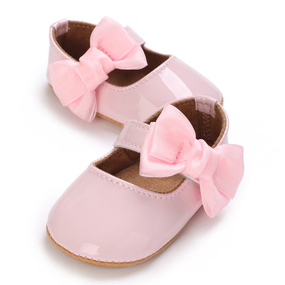 Patent leather shoe with a bow.