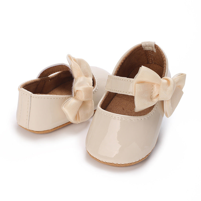 Patent leather shoe with a bow.