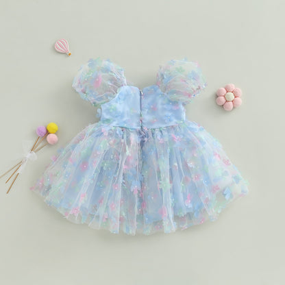 Vestido infantil de tul azul con flores de colores.