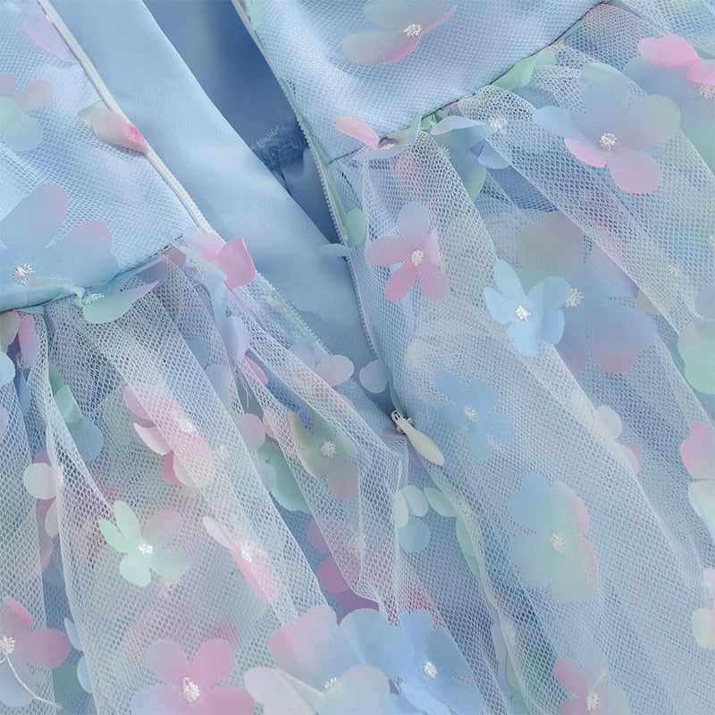Vestido infantil de tul azul con flores de colores.