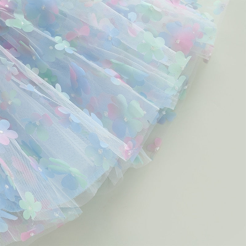 Vestido infantil de tul azul con flores de colores.