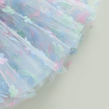 Vestido infantil de tul azul con flores de colores.