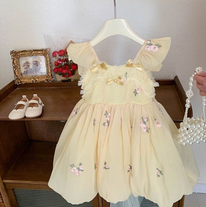 Vestido infantil amarillo con lazo de flores pequeñas 
