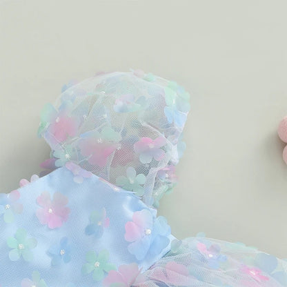 Vestido infantil de tul azul con flores de colores.