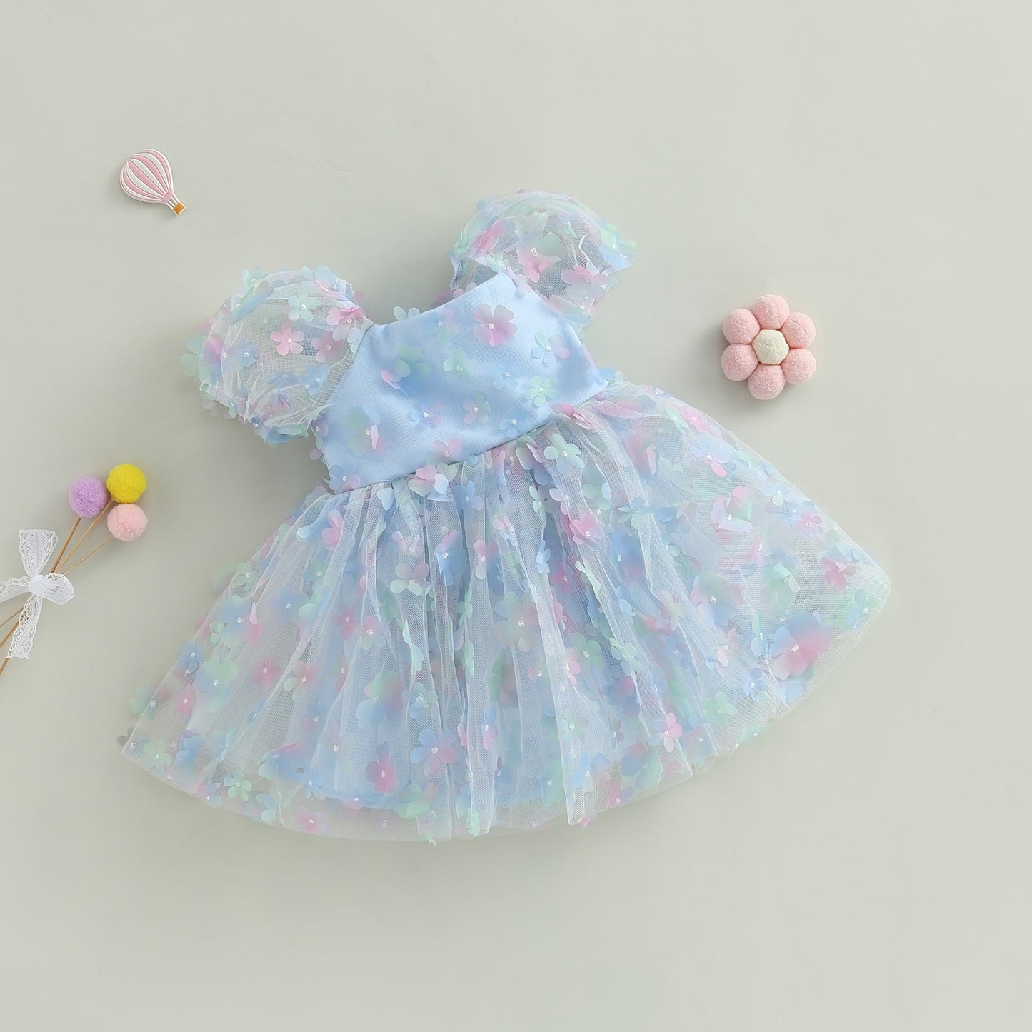 Vestido infantil de tul azul con flores de colores.